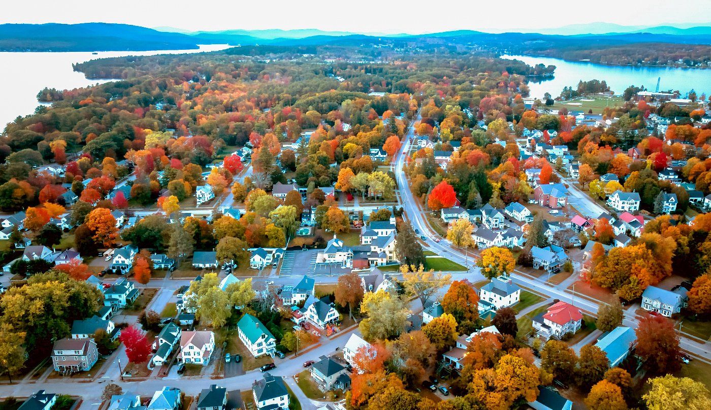 An aerial view of a residential area surrounded by trees in autumn.