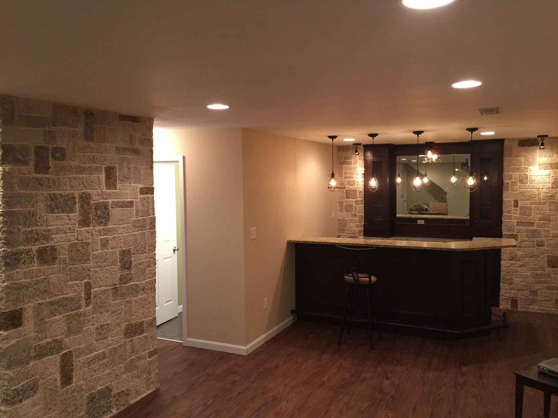 A basement with a bar and a stone wall.
