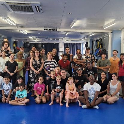 A group of people are posing for a picture in a gym.
