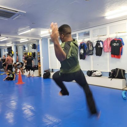 A man is jumping in the air in a gym