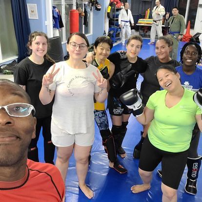 A group of people are posing for a picture in a gym.