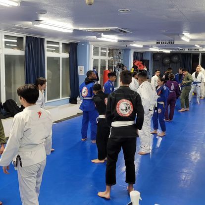 A group of people are practicing martial arts in a gym