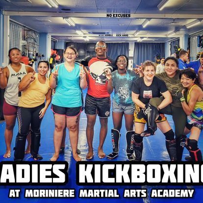 A group of people posing for a picture in a martial arts academy