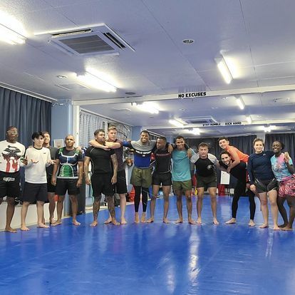 A group of people are posing for a picture in a gym.