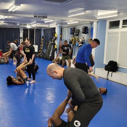 A group of people are practicing martial arts in a gym