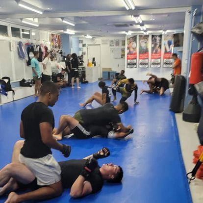 A group of people are practicing martial arts on a blue mat