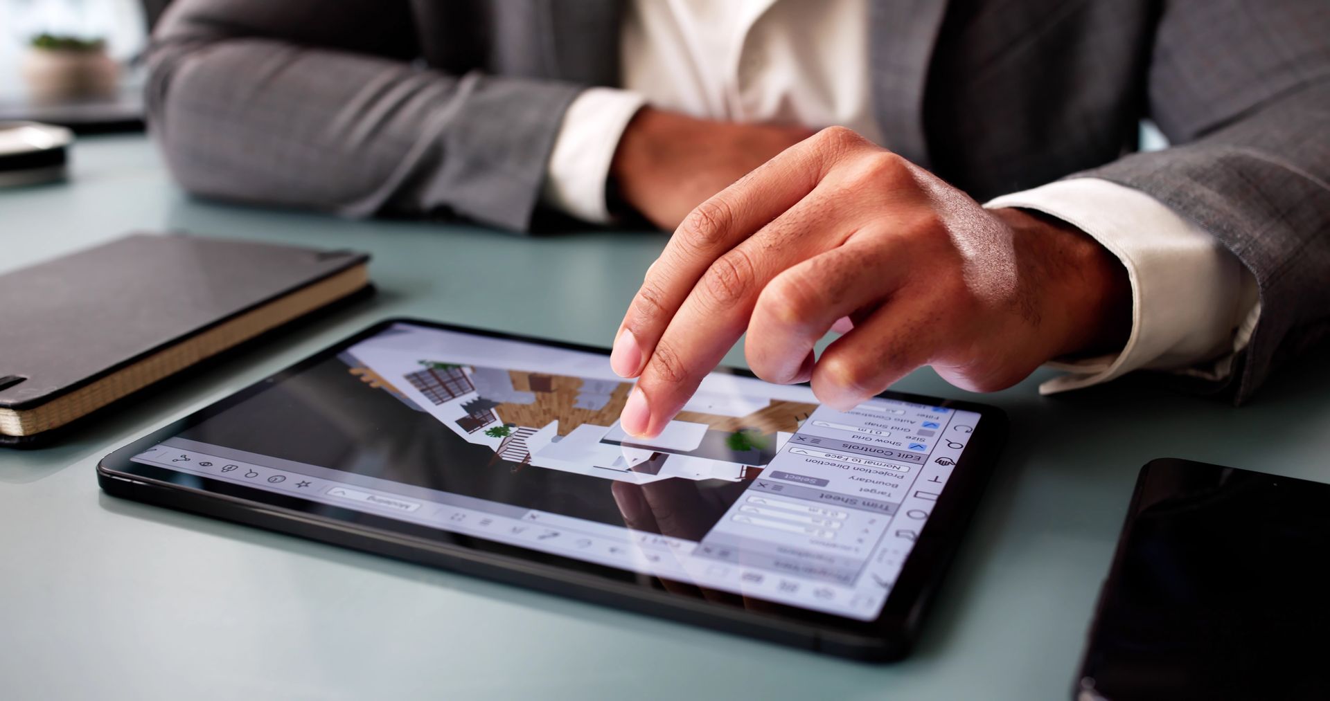 Personne utilisant une tablette, touchant l'écran, visualisant un plan 3D de conception.