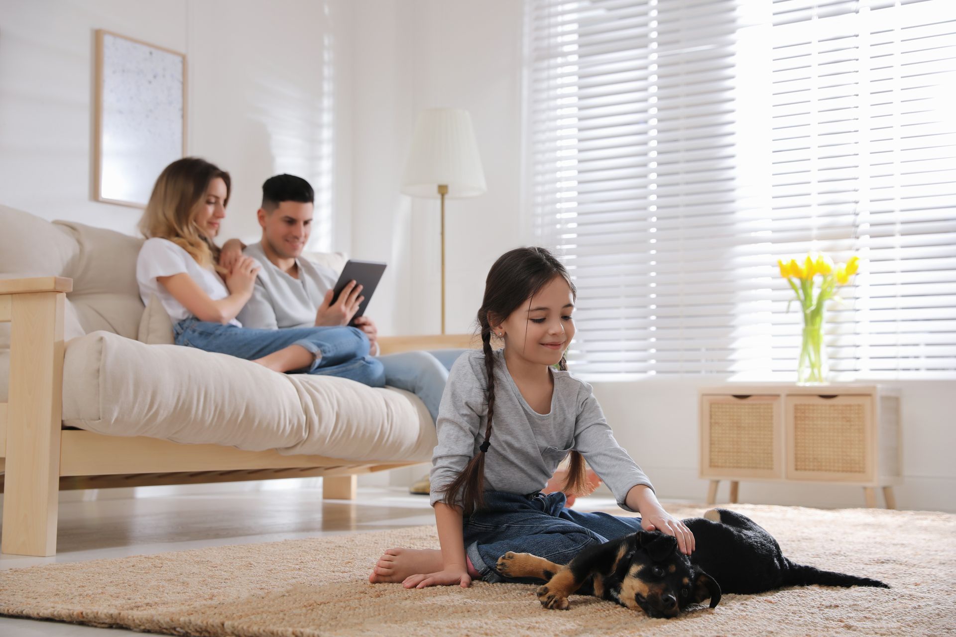 Salon moderne avec mur TV en marbre, étagères intégrées avec livres et barre de son noire.