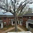Courtyard of red-brick apartment buildings with a large leafless tree in the center