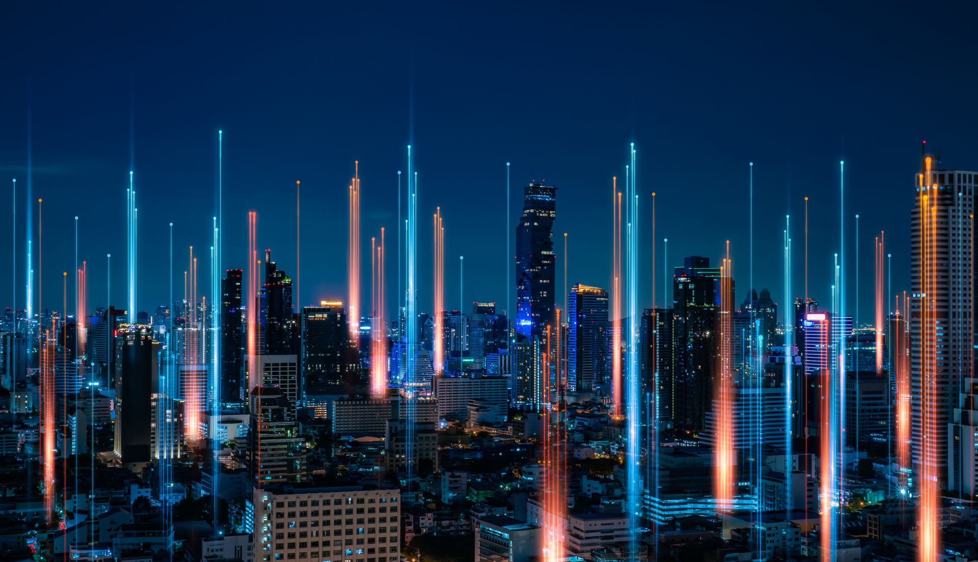City skyline at night with data lines rising from buildings, blue and orange streaks.