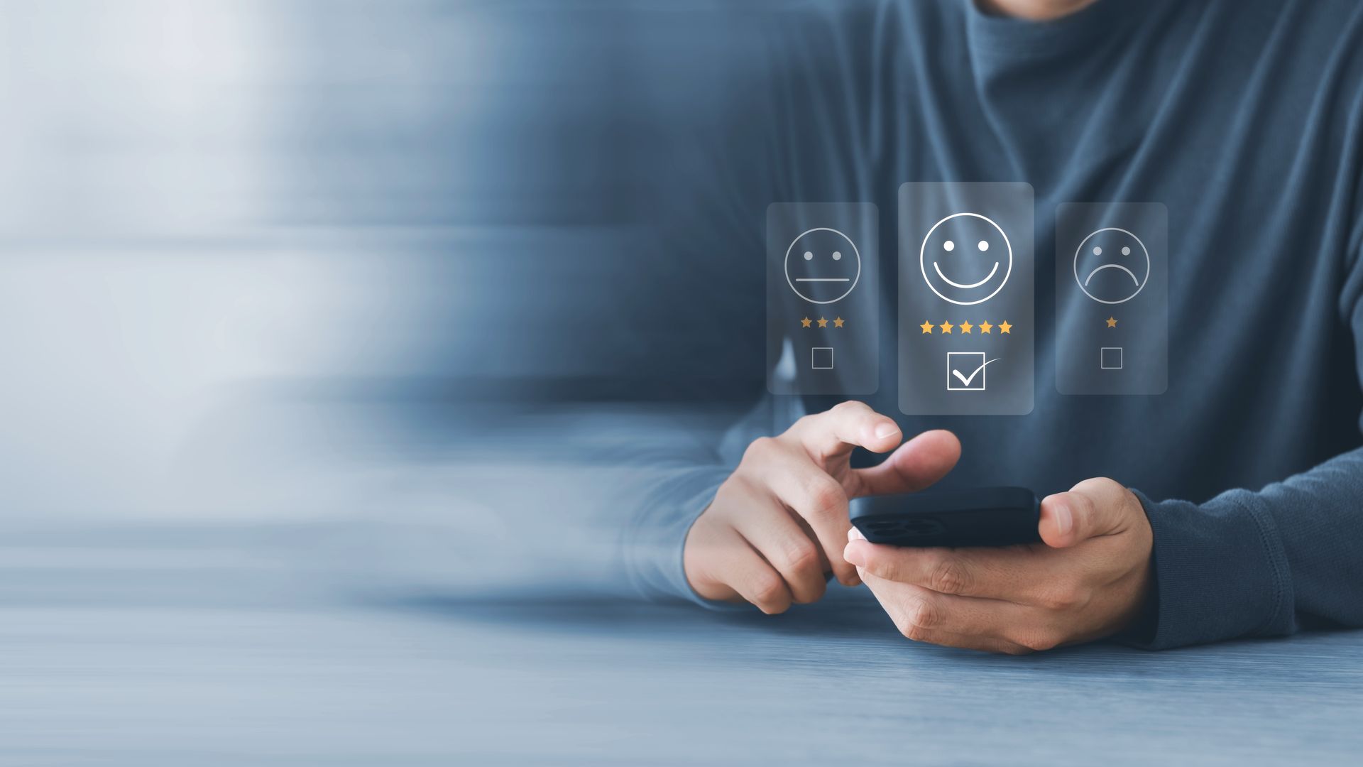 Person using a phone to select a smiling face for customer feedback.