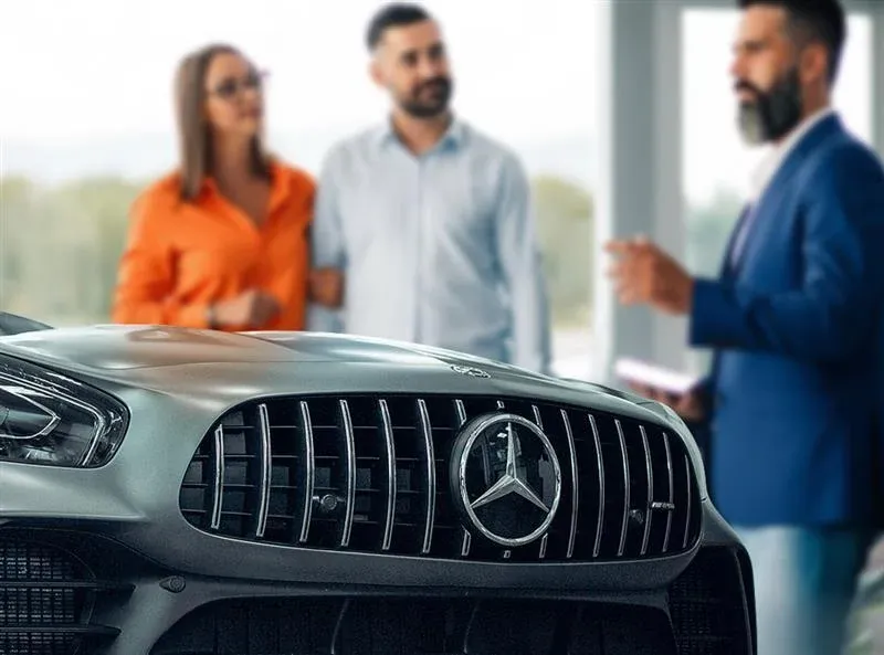 People in business attire reviewing documents, discussing, in an office setting.