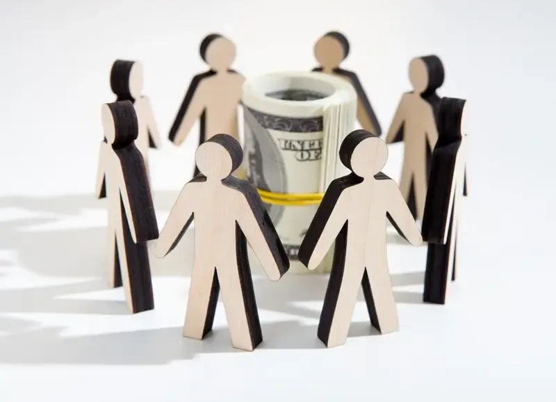 People in business attire reviewing documents, discussing, in an office setting.