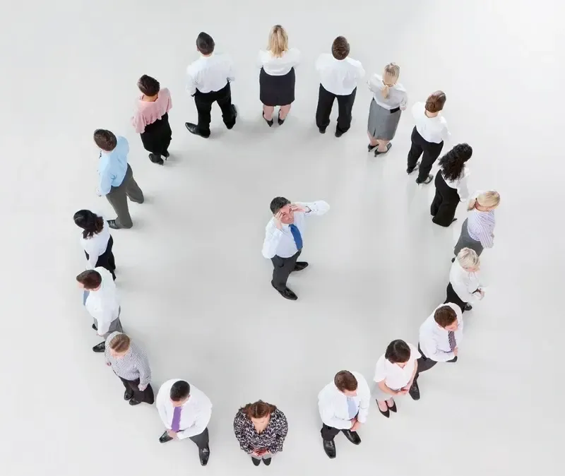People in business attire reviewing documents, discussing, in an office setting.