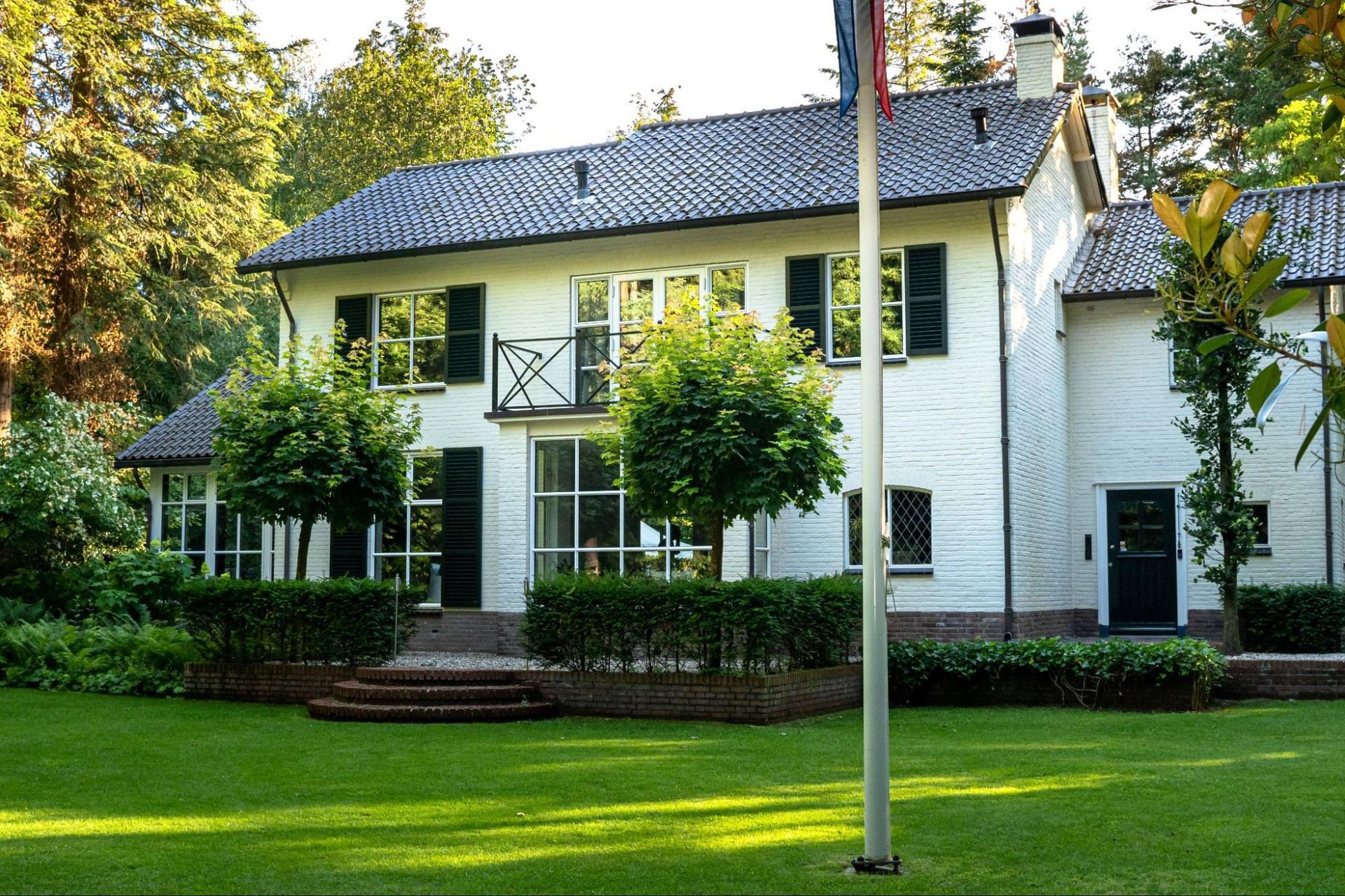 A large white house with a flag in front of it