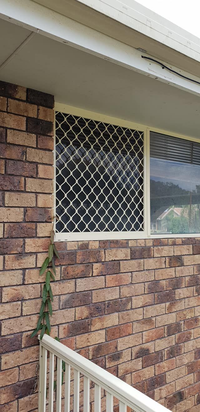 A Brick Building With a Window and a White Screen — North Coast Screens & Repairs in Lennox Head, NSW