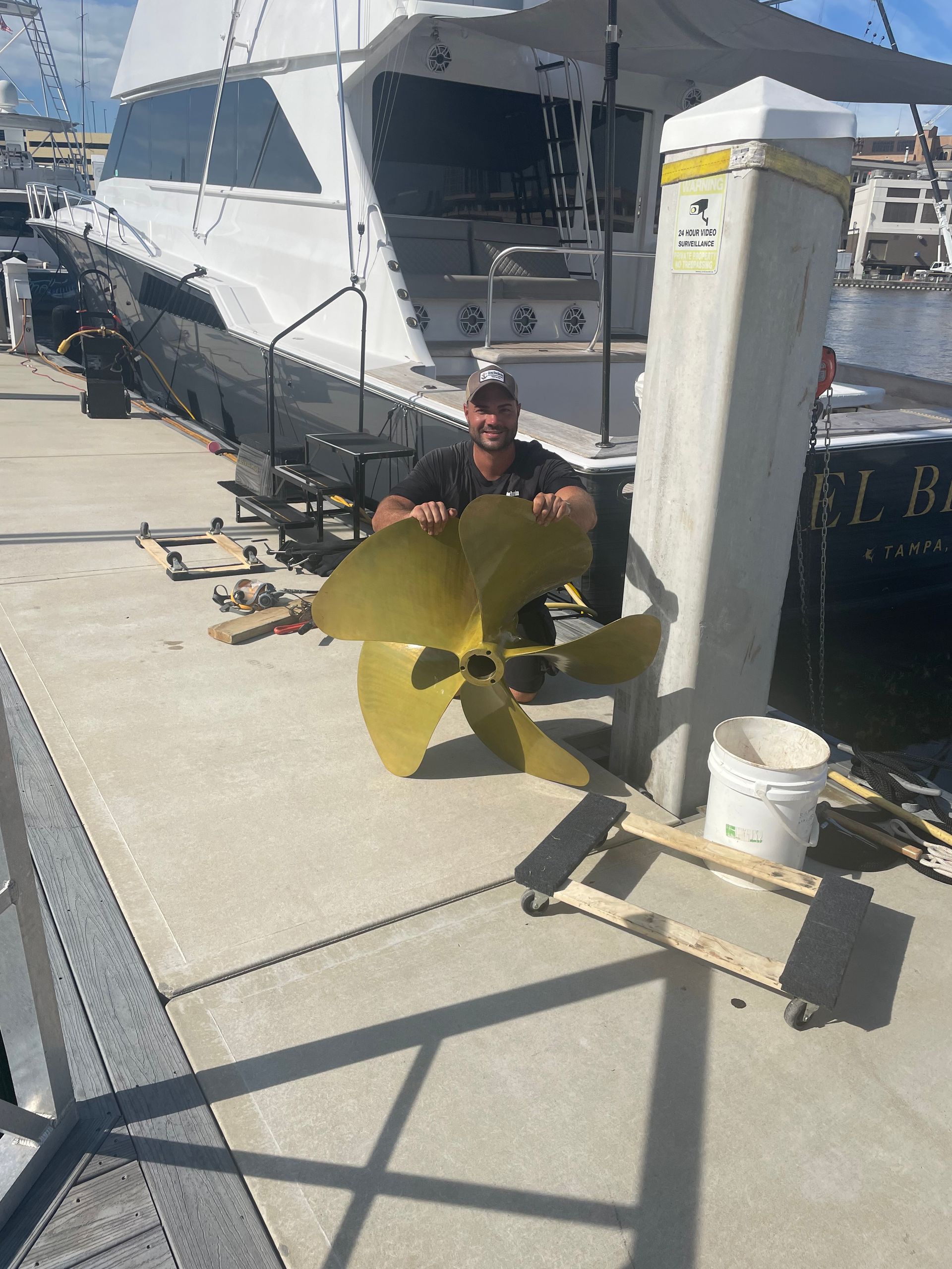 A Man is Sitting Next to a Large Boat Propeller — Palm Harbor, FL — Ozona Dive Service