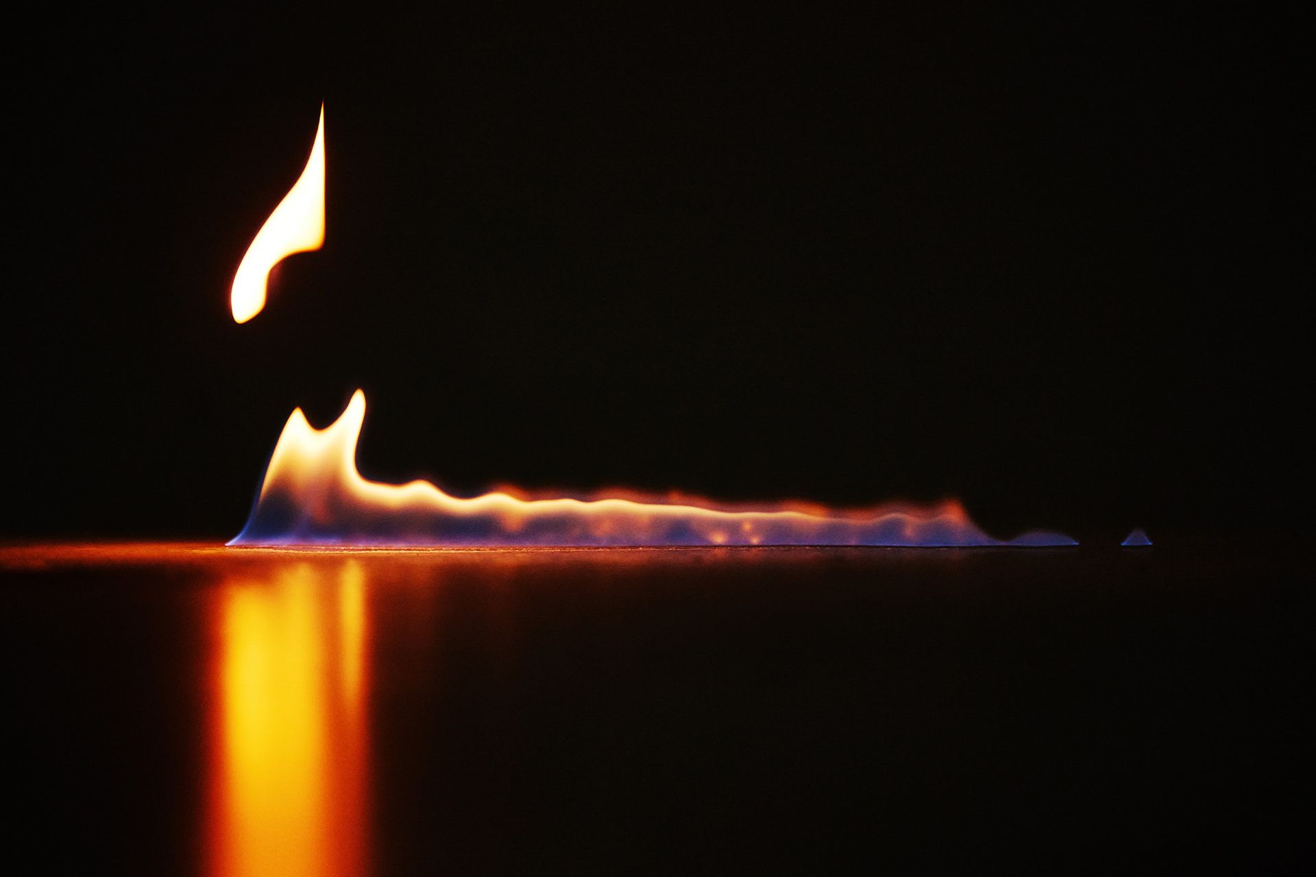 A candle is lit up in the dark and looks like a volcano