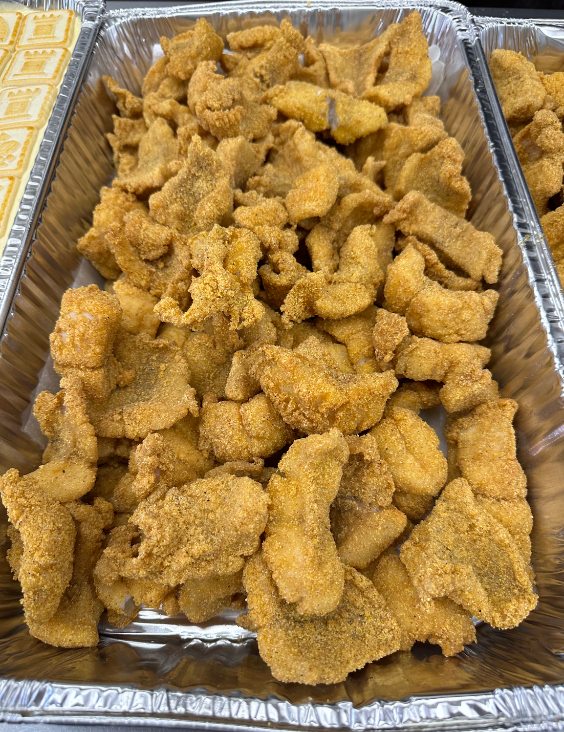 A tray of fried fish is sitting on a table.