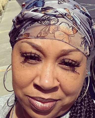 A woman wearing a headband with butterflies on it and earrings.
