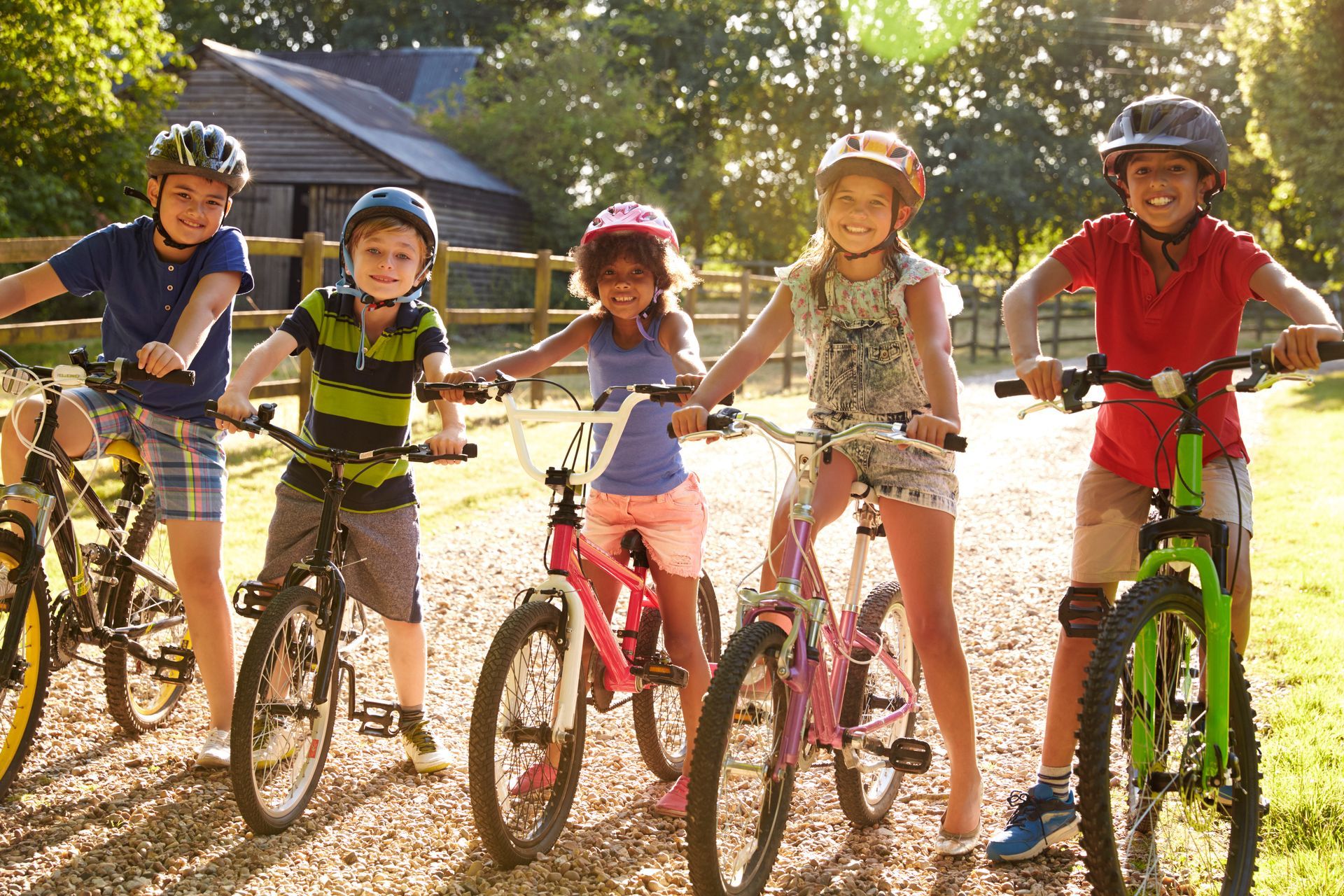 Children on bikes wearing helmets outdoors.