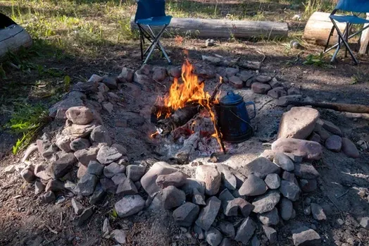 A campfire is sitting in the middle of a rocky area.