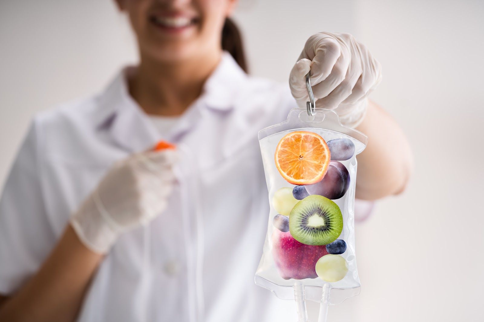 Hand holding a clear pouch of mixed fruit, with a smiling person blurred in the background