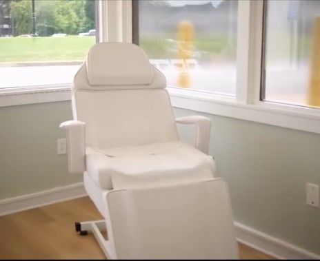 White padded lift chair by a window in a bright room