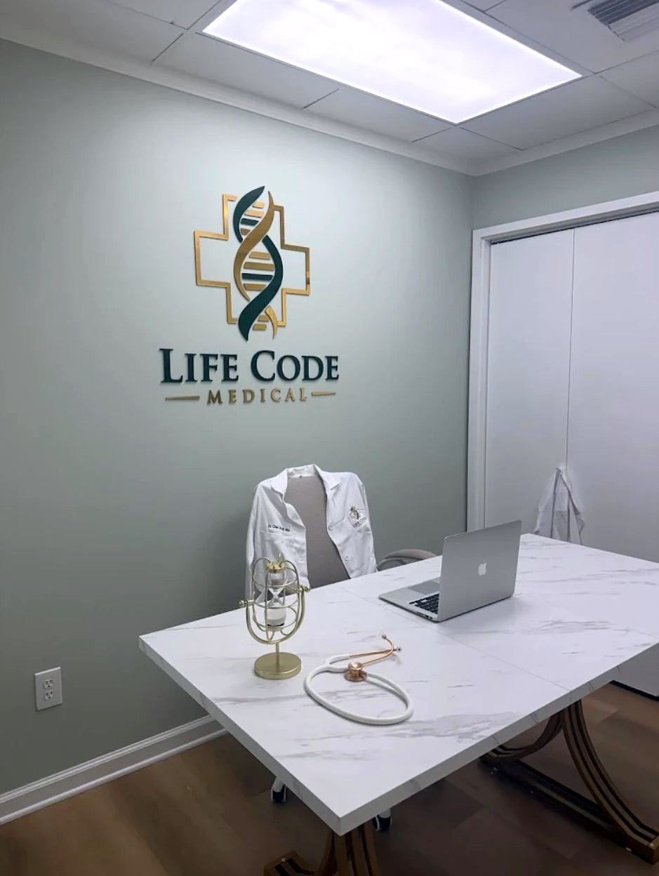 Life Code Medical conference room with white table, laptop, chairs, and wall logo