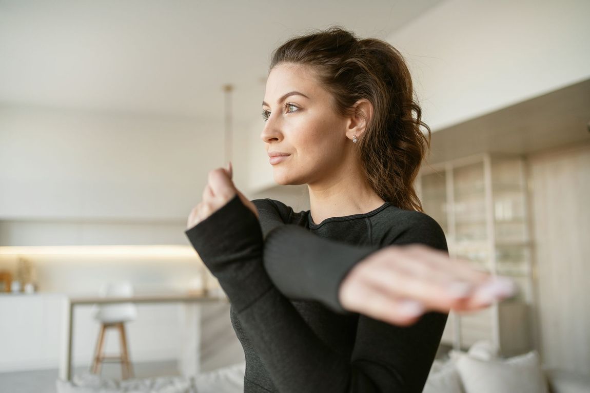 Woman stretching her arms in a bright living room
