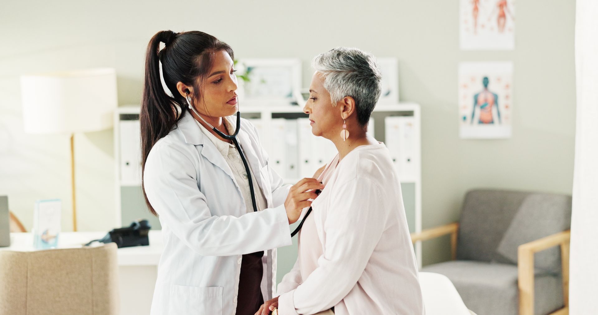Doctor examining a patient in a bright home bedroom