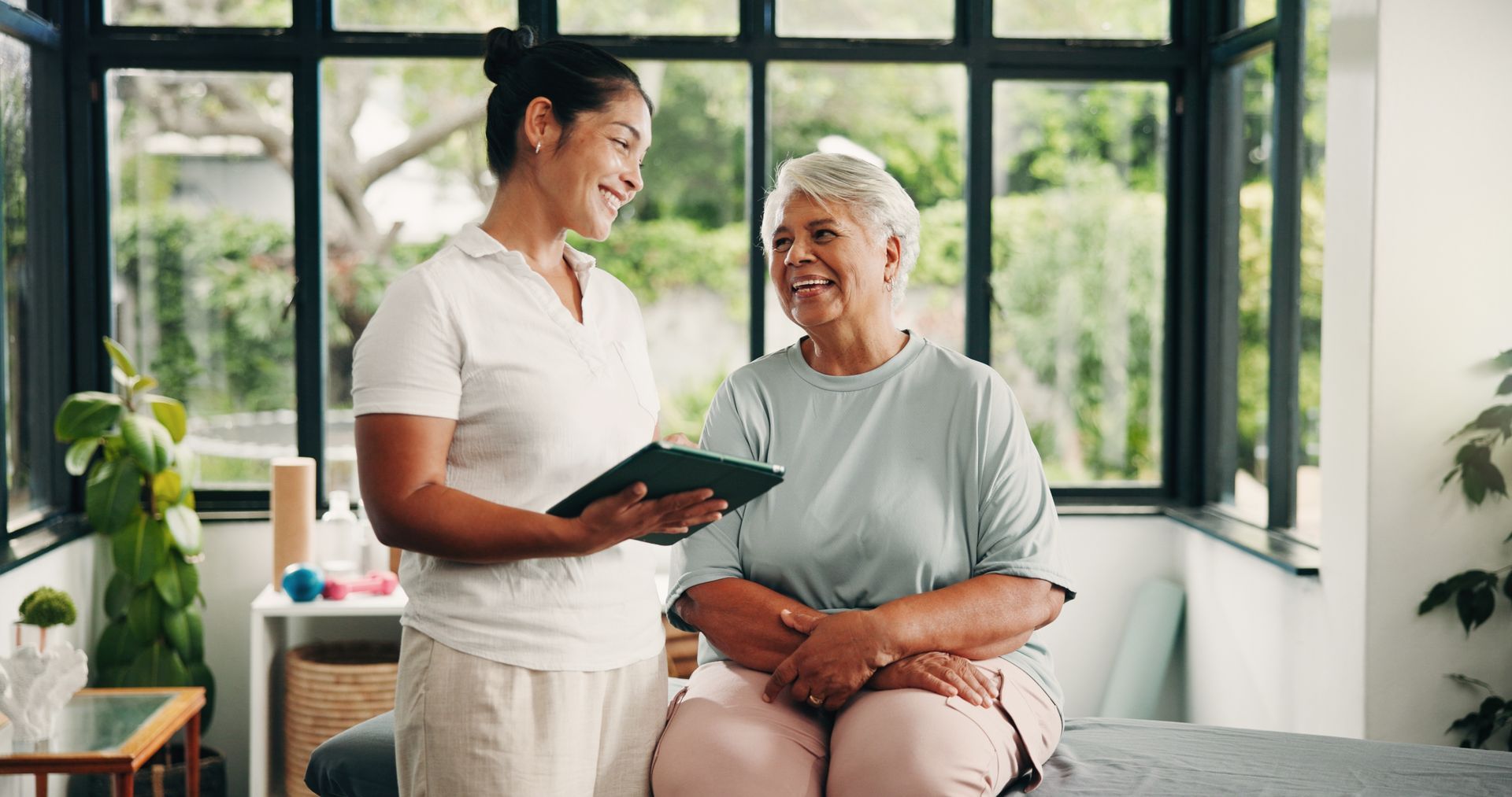 Healthcare worker consulting with an elderly patient in a bright, modern clinic room