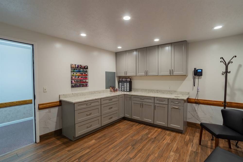 Modern room with gray cabinets, wood floor, countertop, bench seating, and wall-mounted phone.