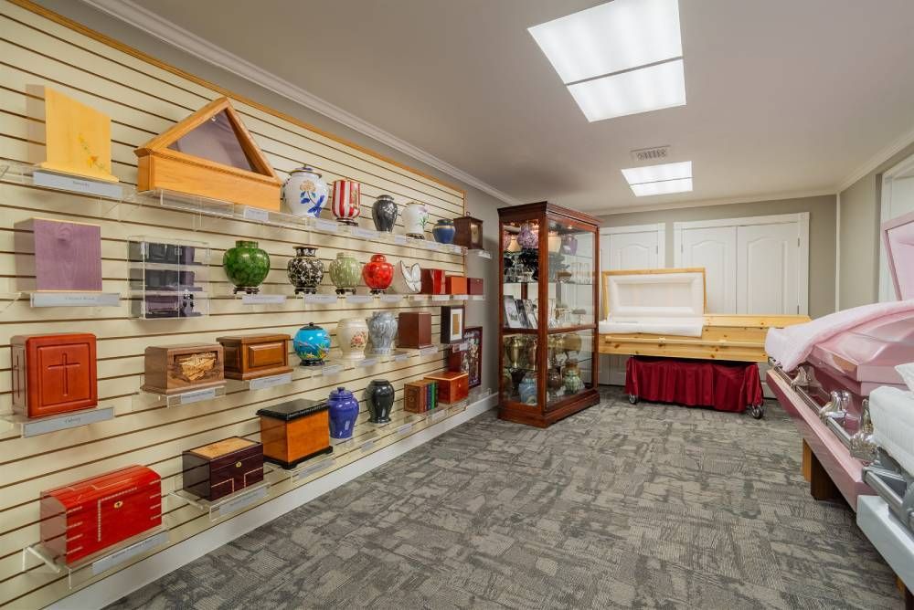 Display room with shelves of colorful small pet cages, a glass cabinet, and a pet exam table with a pink cover.