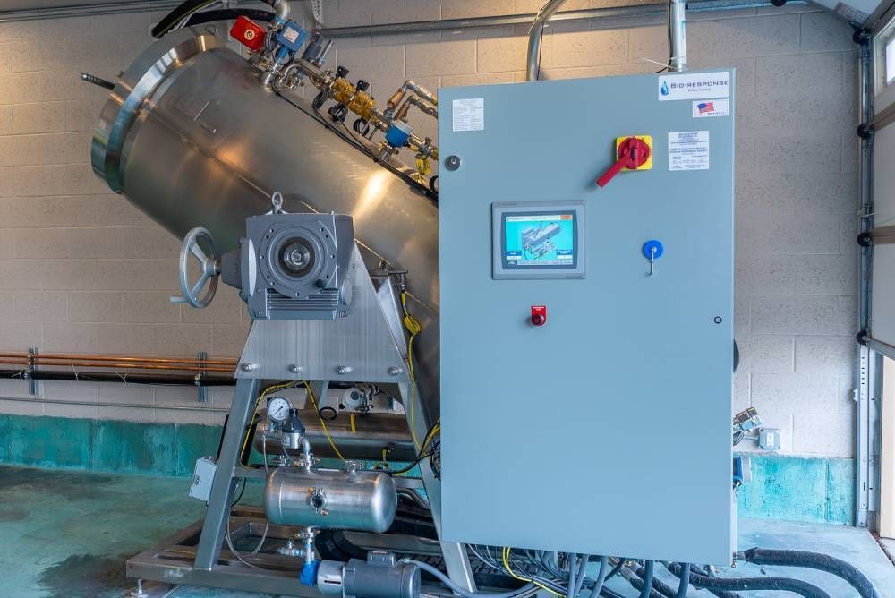 Industrial stainless-steel machine with a gray control panel in a factory setting