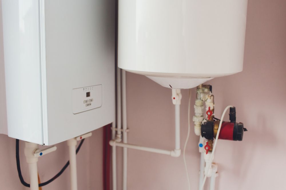 Two Water Heaters Are Sitting Next To Each Other In A Room — Panorama Plumbing In Dubbo, NSW