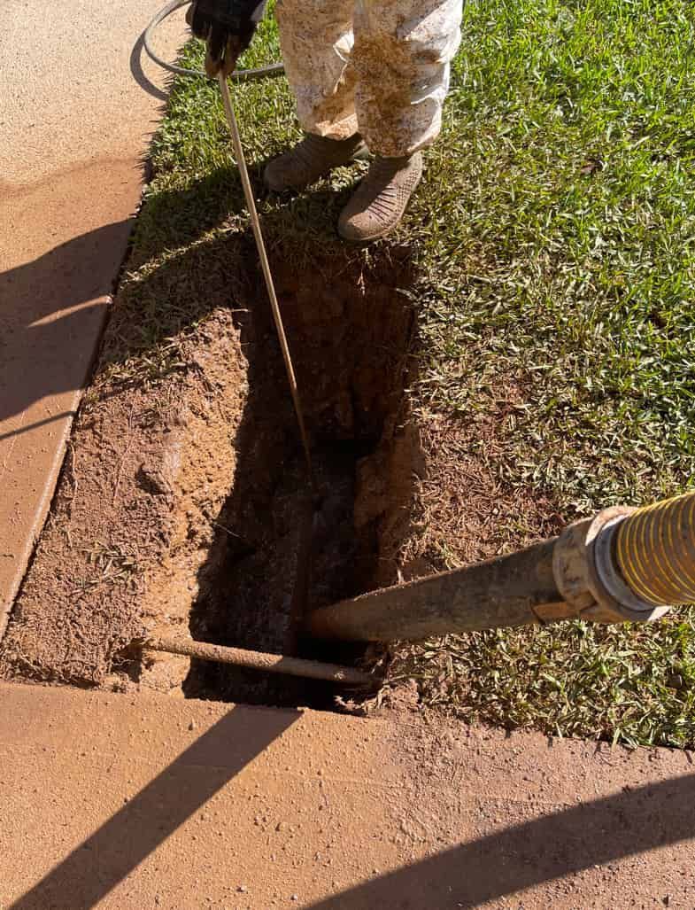 A Person Is Pumping Water Into A Hole In The Ground — Panorama Plumbing In Dubbo, NSW