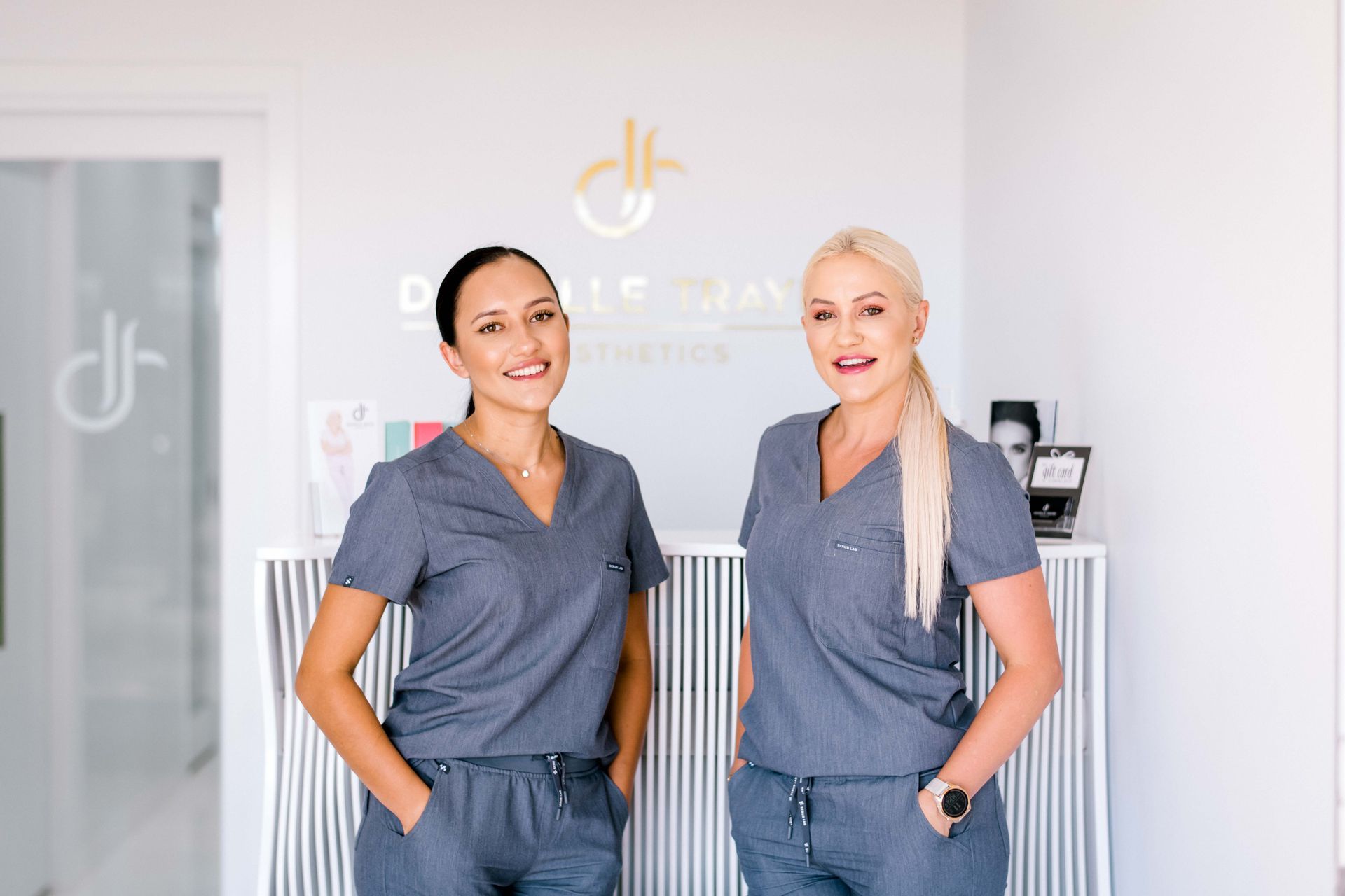 Two women in scrubs are standing next to each other in a room.