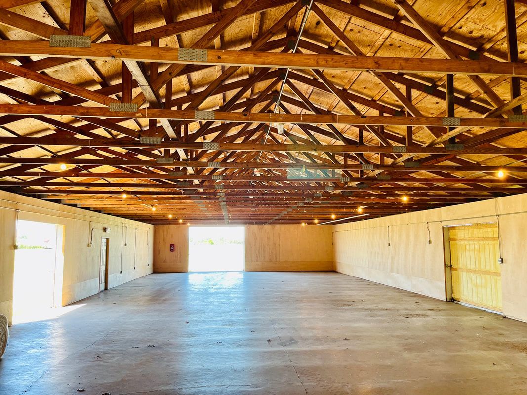 A large empty room with a wooden ceiling and a yellow door.
