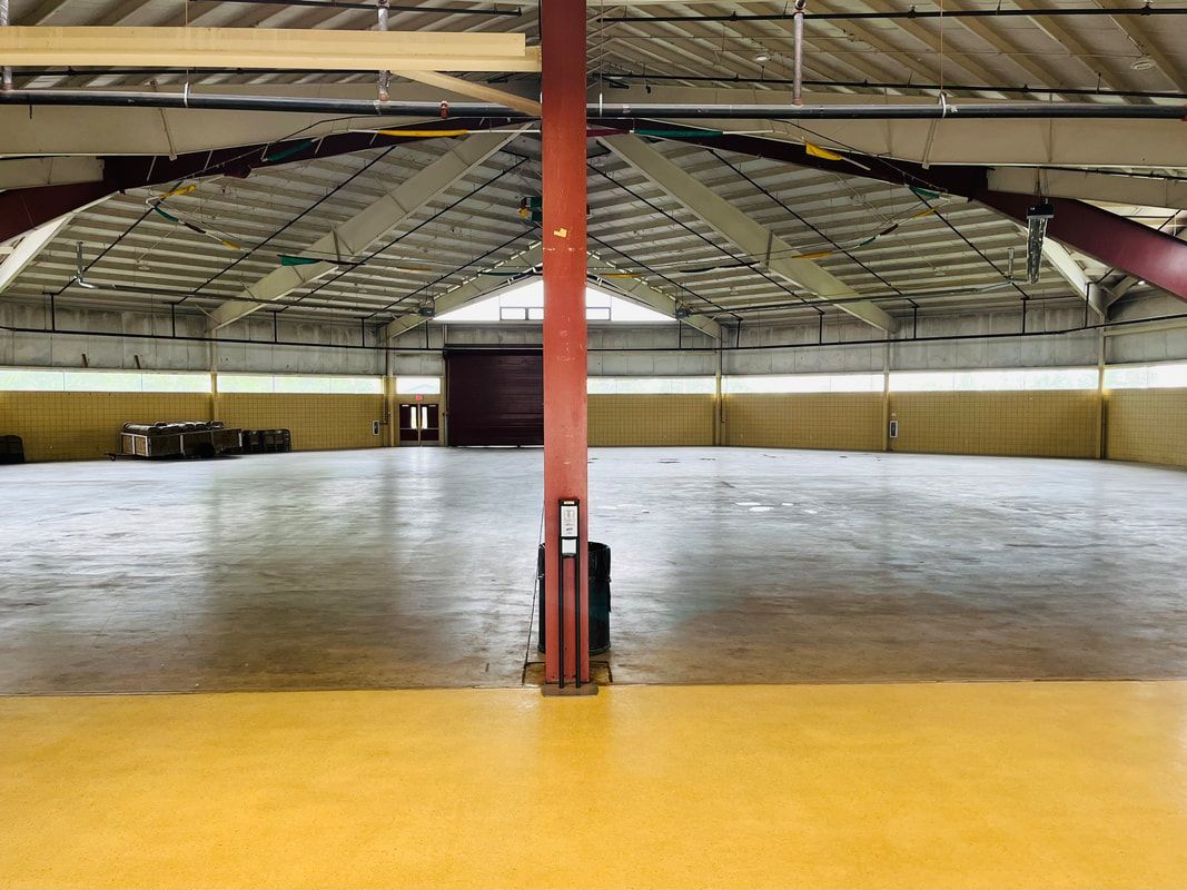 A large empty warehouse with a red pole in the middle