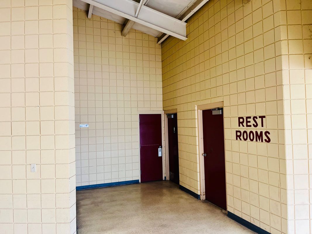 A brick wall with restrooms painted on it