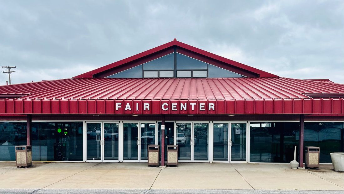 The fair center is a large building with a red roof.