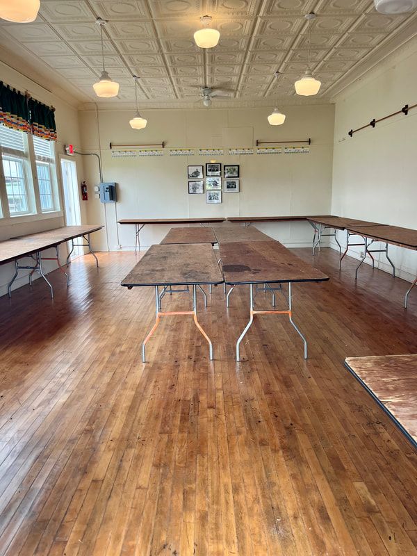A large room with wooden floors and tables in it.