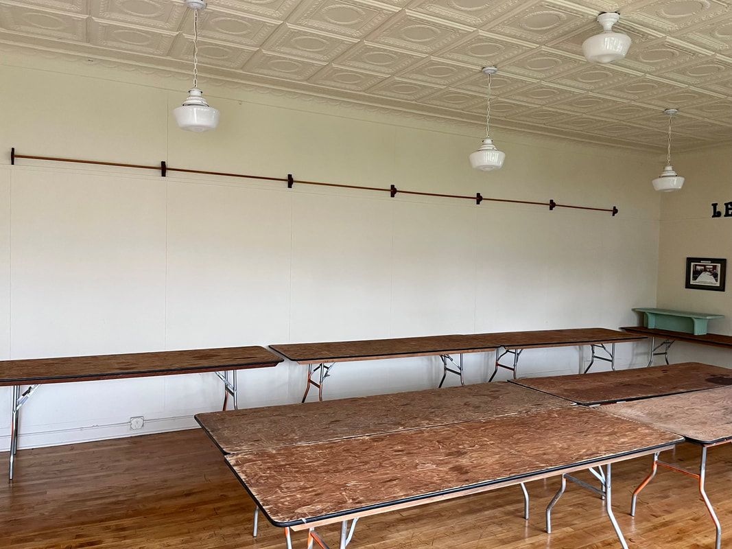 A room with tables and a white board on the wall.