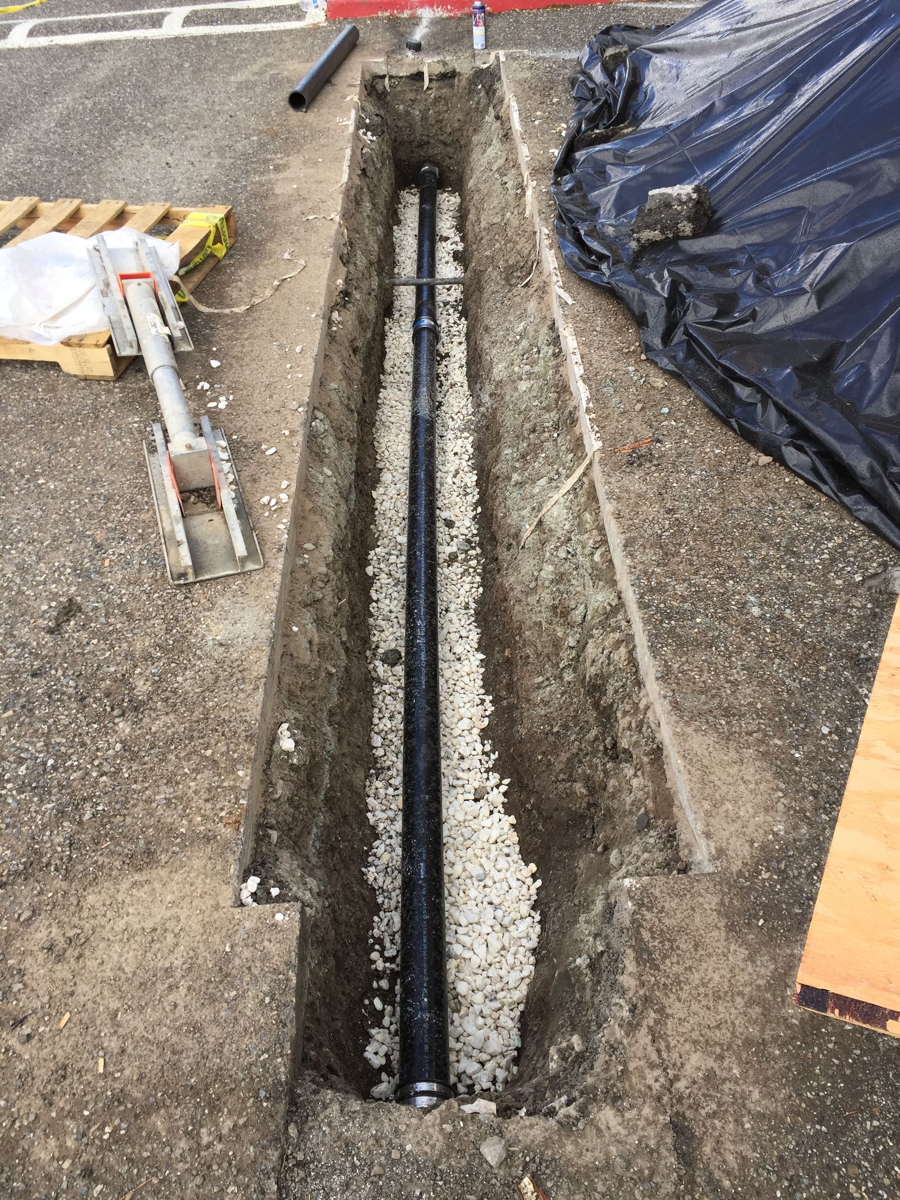 A pipe is being installed in a hole in the ground.