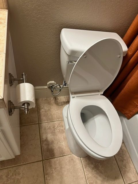 A bathroom with a toilet and a roll of toilet paper