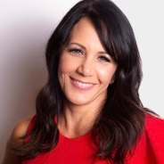 Kelly Devlin in a red dress is smiling for the camera .