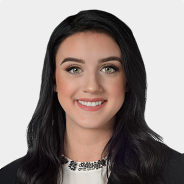 Shelby Harris with long black hair is smiling for the camera .