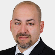 Ted Hernandez with a beard is wearing a suit and tie