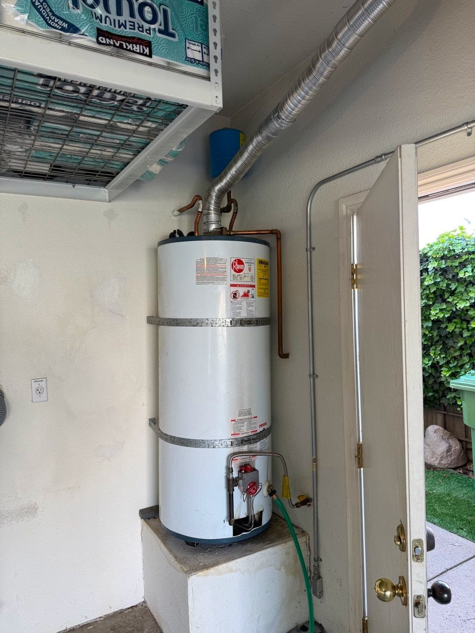 Utility closet with a tall water heater, shelves, and cleaning supplies; “Before” label at bottom.